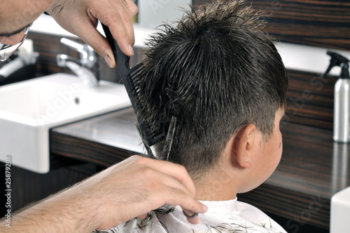 Barber cutting hair with scissor