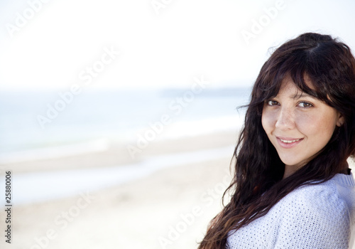 Pretty young woman with standing on beach