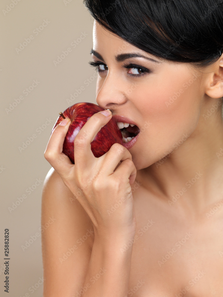 Portrait of beautiful woman, she bites red apple Portrait of beautiful woman, she bites red apple
