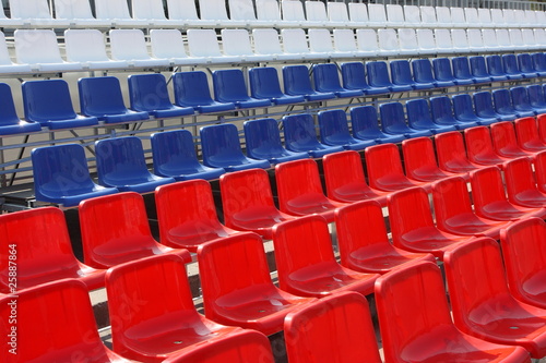 Rows of red, blue and white plastic chairs