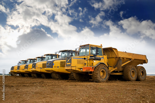 Row of yellow heavy tipper trucks