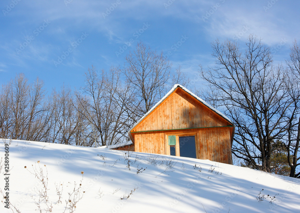 Wooden cottage against a blue sky in the winter