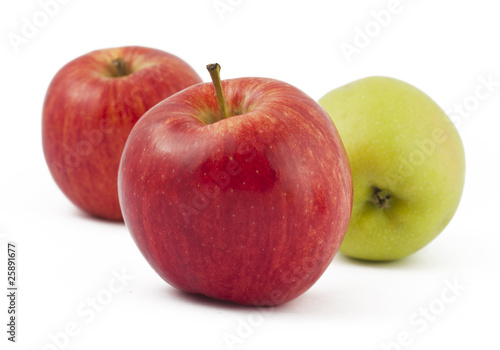 Two red and one green apples on white