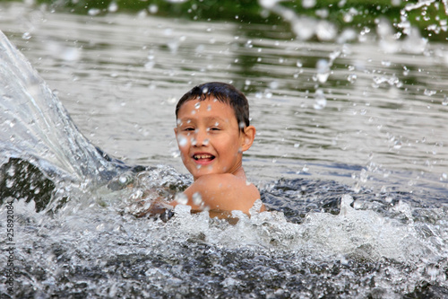 boy in river with splash