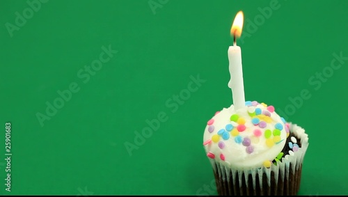 Single birthday cupcake over green