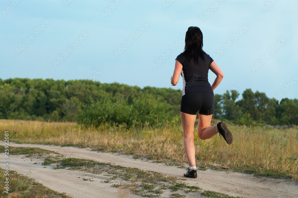 Woman jogging outdoors on the meadow