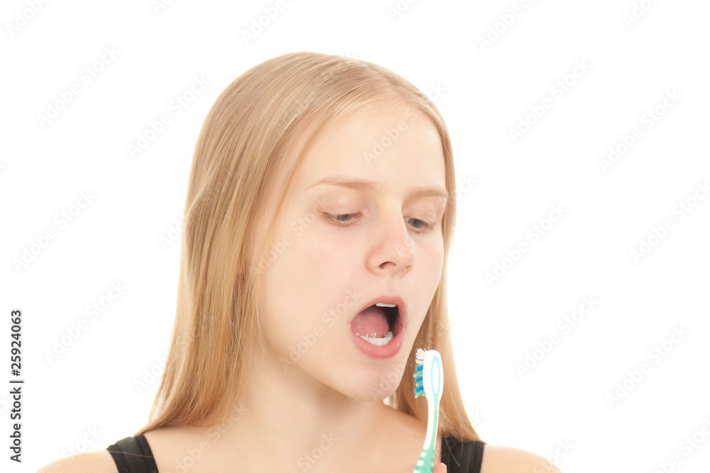 A young woman looks to the teethbrush brushing her teeth A young woman looks to the teethbrush brushing her teeth