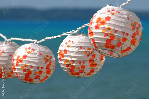 Colorful paper lamps on summer with a blue background