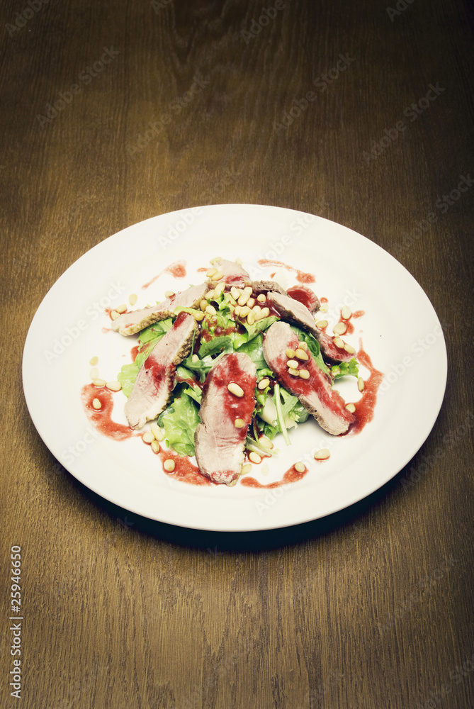 Meat with salad served on the white round plate Meat with salad served on the white round plate