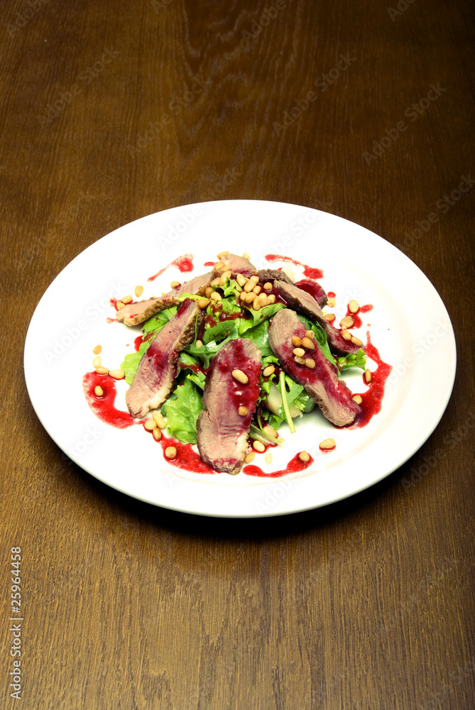 Meat with salad served on the white round  plate
