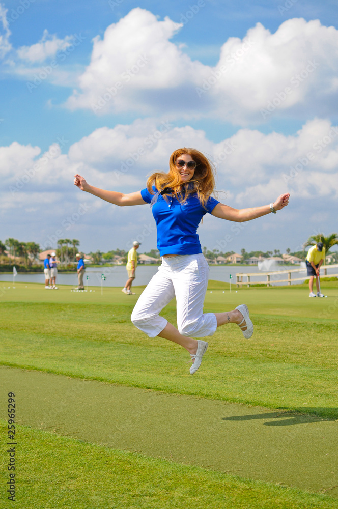 Woman with Red Hair jumping on golf course