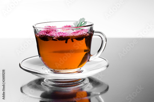 cup of herbal tea with flowers on glossy background