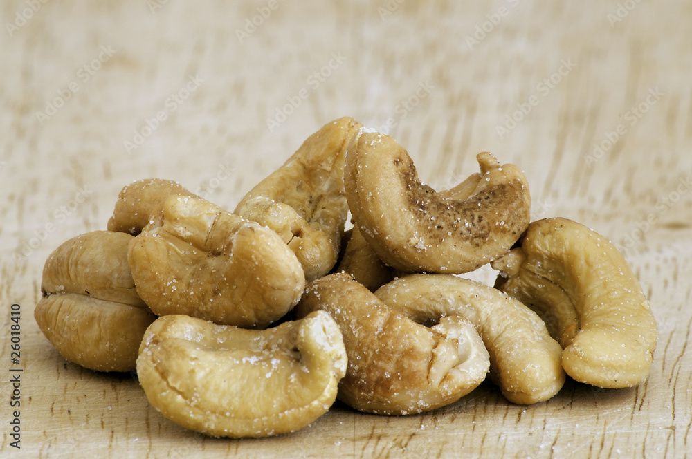 Heap of a roasted cashew nuts on an old wooden table.