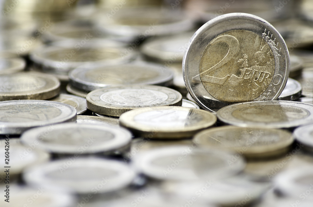 Grungy 2 euro coin with coins on background Grungy 2 euro coin with coins on background