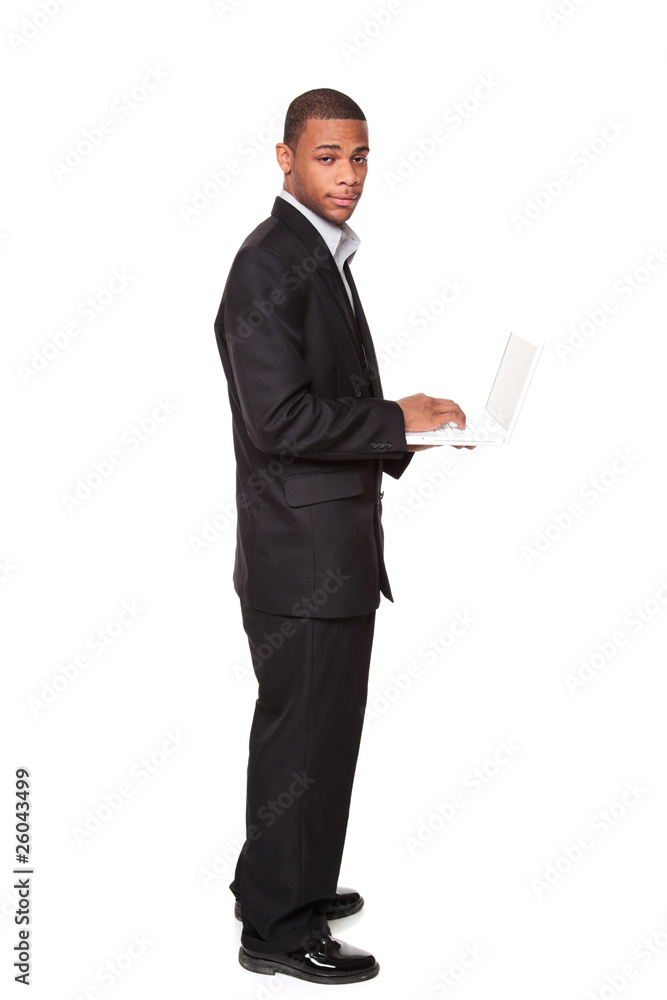 African American businessman standing while using notebook compu African American businessman standing while using notebook compu