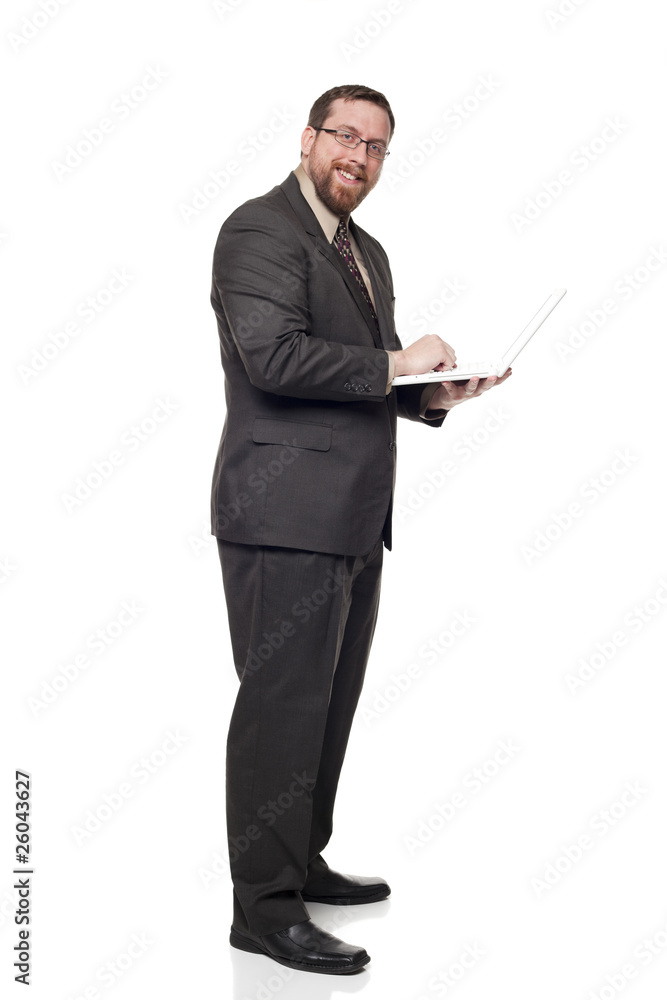 Side view Caucasian businessman working on laptop while standing Side view Caucasian businessman working on laptop while standing