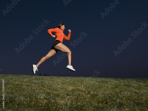 Mixed race woman running on grass