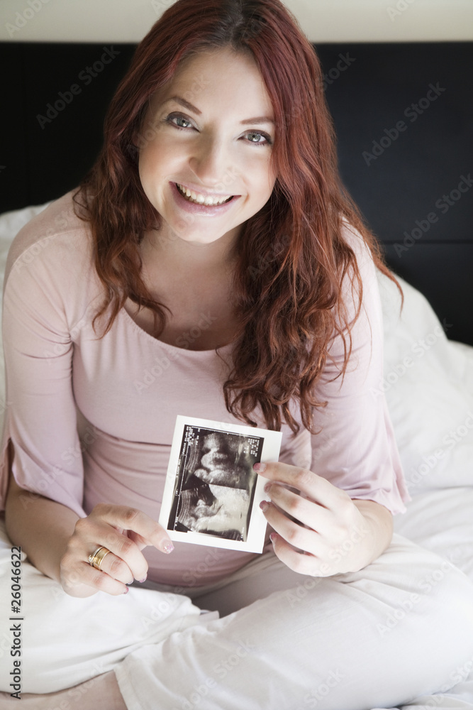 Pregnant Hispanic woman holding sonogram picture Pregnant Hispanic woman holding sonogram picture
