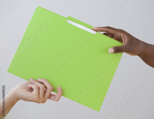 African woman handing co-worker a folder
