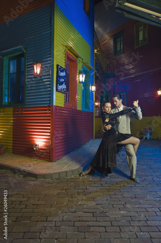 Hispanic couple performing tango on city street photo