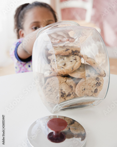 African girl taking cookie from jar