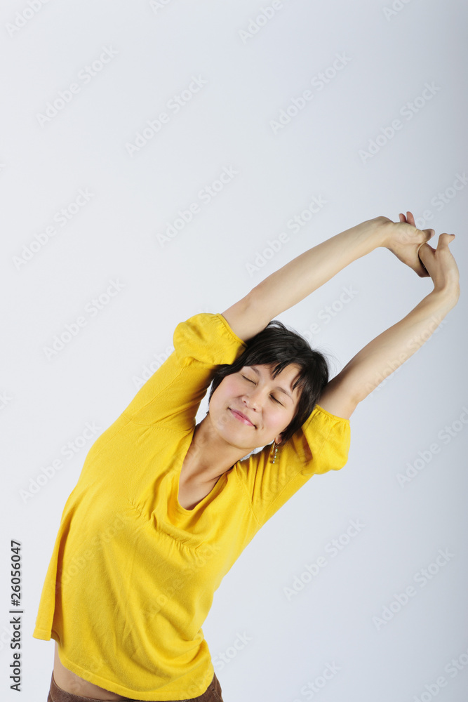 Filipino woman stretching arms overhead Filipino woman stretching arms overhead