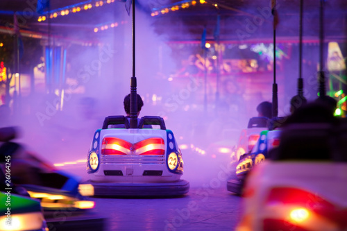 Bumper cars, driving through artificial smoke. Motion blur