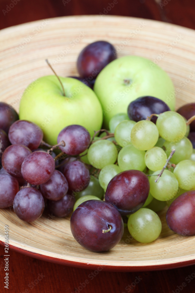 Bowl with fresh organic apples, grapes and plums Bowl with fresh organic apples, grapes and plums