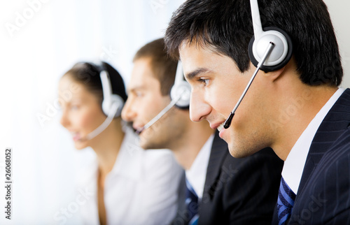 Three support phone operators at workplace photo