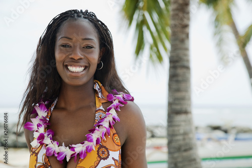 African woman wearing lei on beach photo