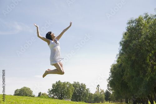 Hispanic woman jumping in mid-air