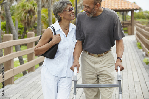 African woman walking with husband using walker