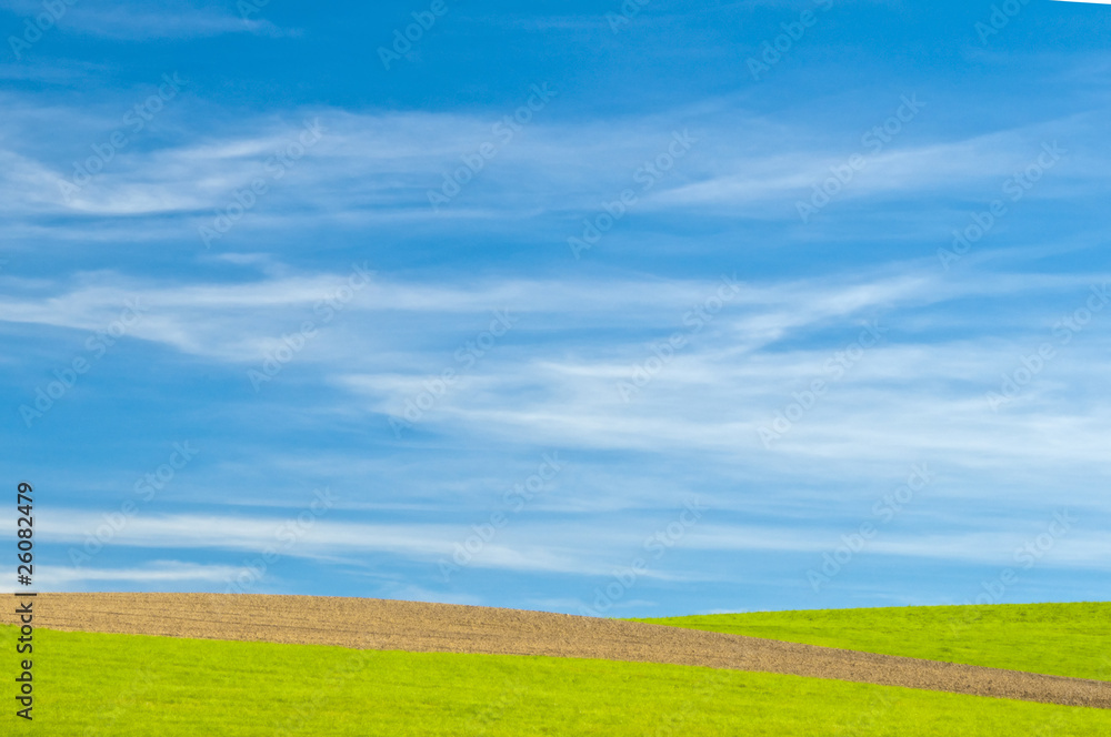 Wiese mit Acker bei blauem Himmel mit Schleierwolken Wiese mit Acker bei blauem Himmel mit Schleierwolken