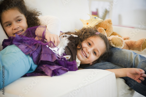 Hispanic sisters in costumes sleeping on couch photo