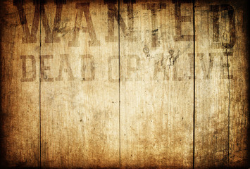 Old western wanted sign on wooden wall.