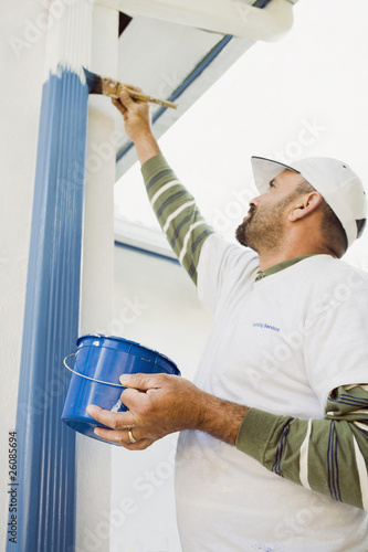 Latin man painting gutters