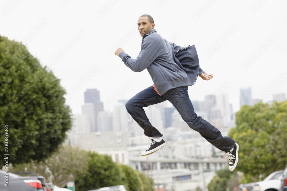 African American man running on urban street African American man running on urban street