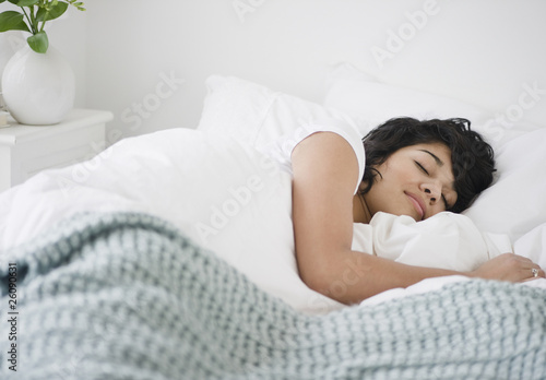 Hispanic woman sleeping in bed