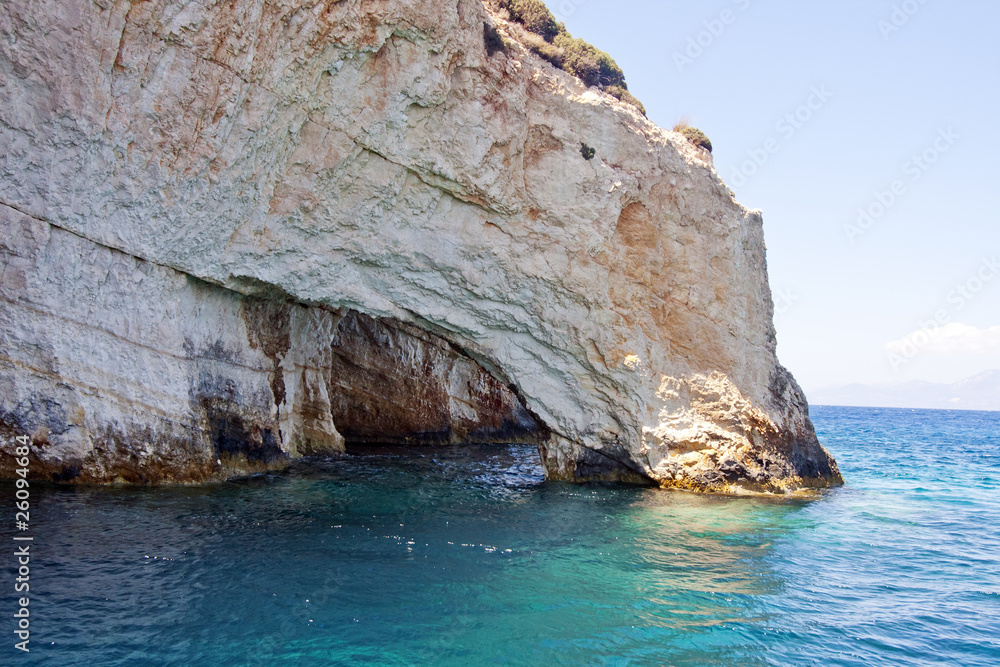 Fototapeta premium rocky cliff surrounded by blue ocean