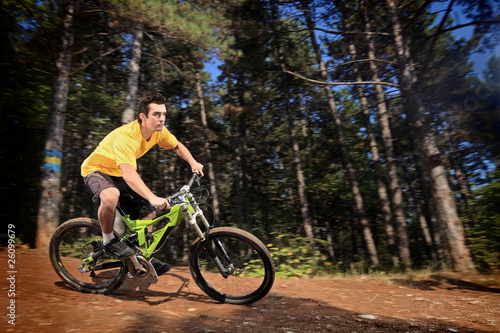 Young man riding a mountain bike downhill style