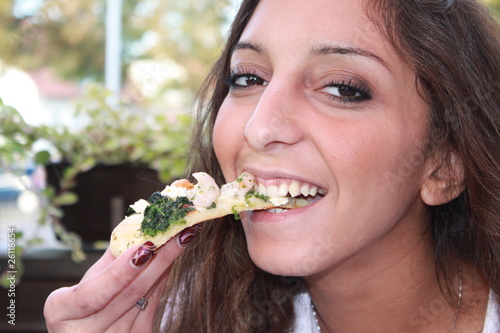 Eine junge Frau isst ein leckeres Stück Pizza © Schulz-Design