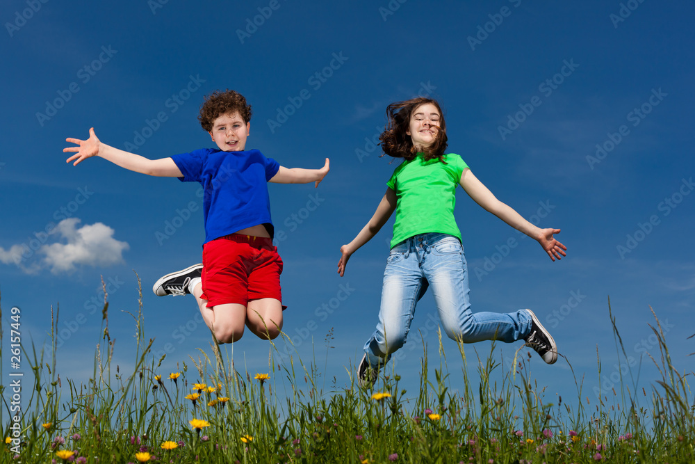 Girl and boy jumping, running against blue sky Girl and boy jumping, running against blue sky