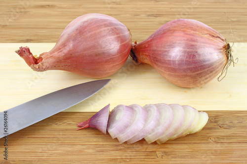 Sliced shallot on cutting board with knife