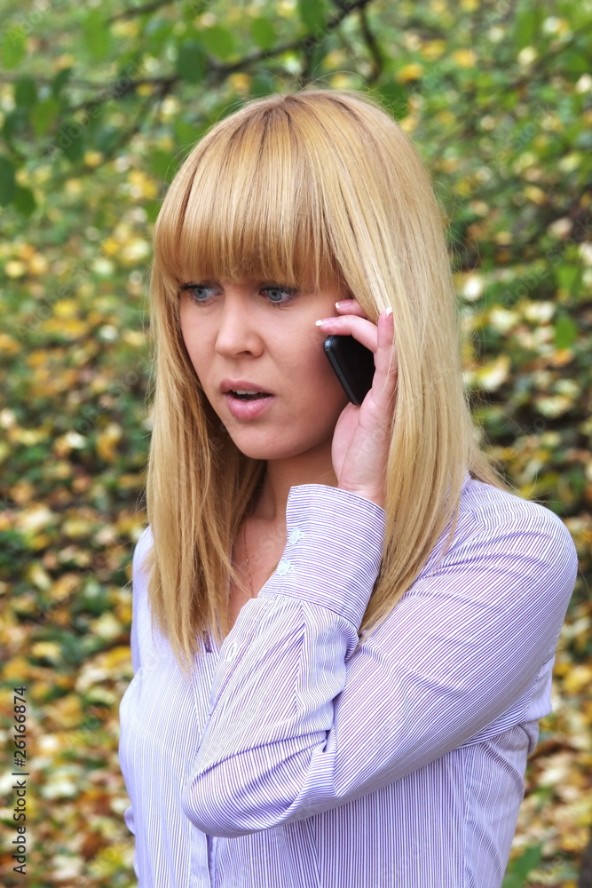 a young girl on nature speaks by phone a young girl on nature speaks by phone
