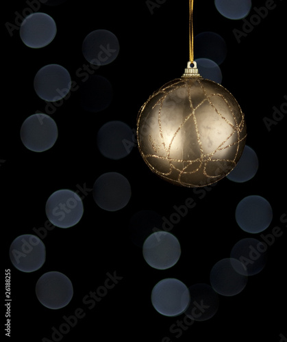 Golden Christmas decoration ball. Blurry lights on background.