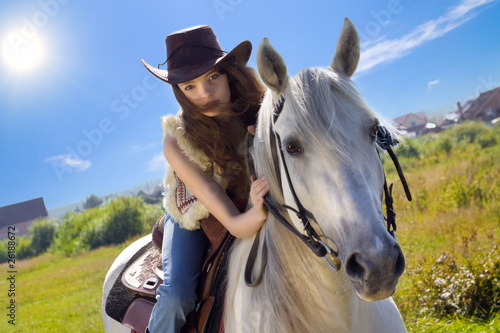 young cowgirl gallop on white horse