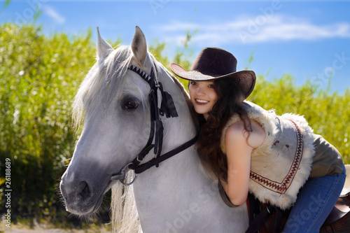 young cowgirl on white horse smile