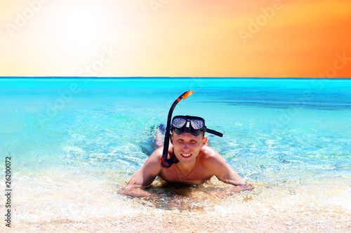 Happy young man with snorkelling on a sea beach
