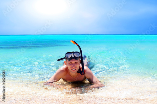 Happy young man with snorkelling on a sea beach