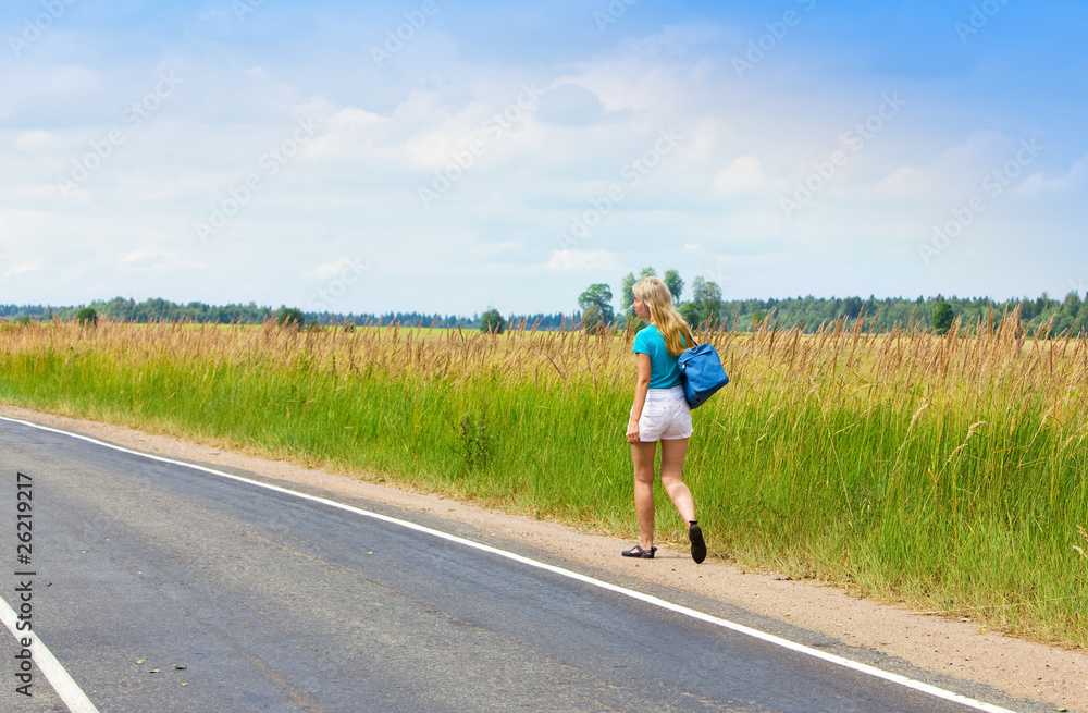 Obraz premium Beautiful young woman with luggage on road..